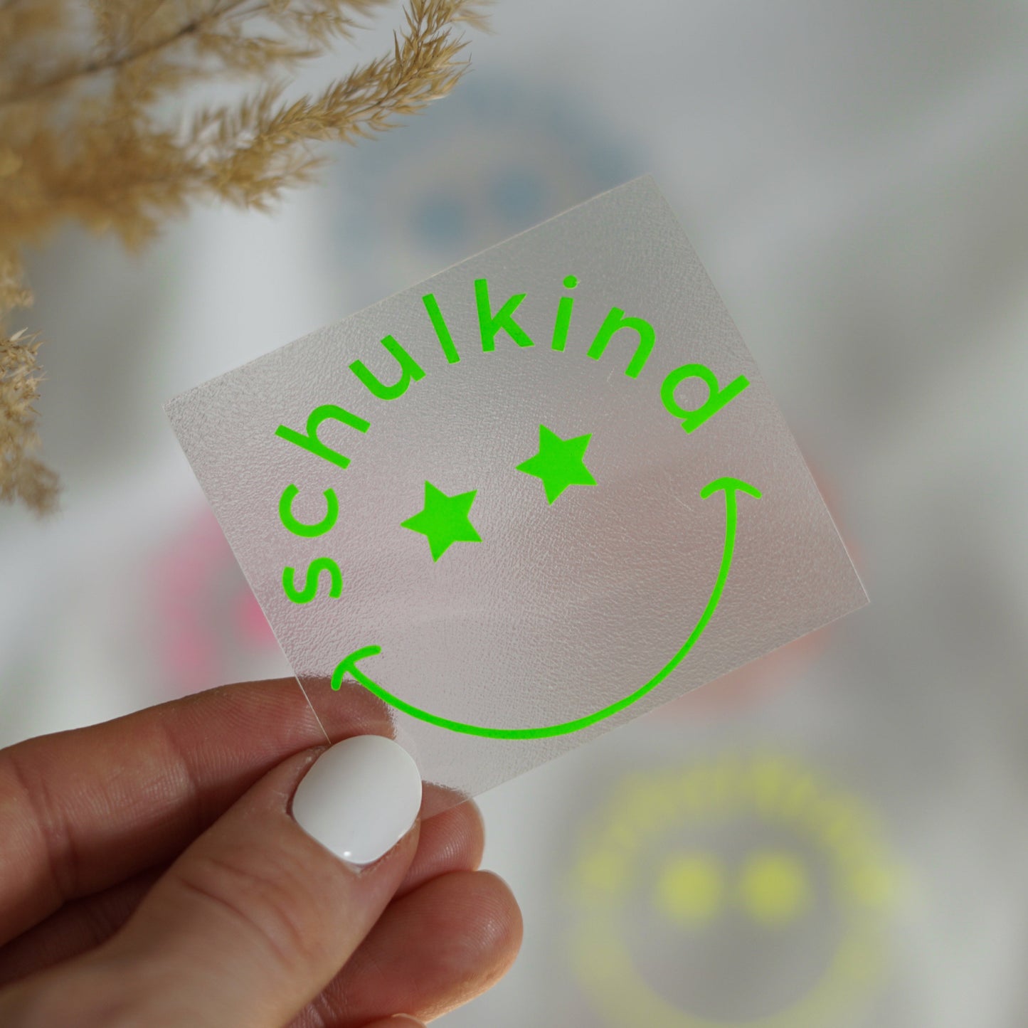 Neon Bügelbild – Schulkind mit lachendem Gesicht und Sternenaugen – leuchtendes Aufbügelmotiv für die Einschulung in Neon Pink, Gelb, Orange, Grün & Blau