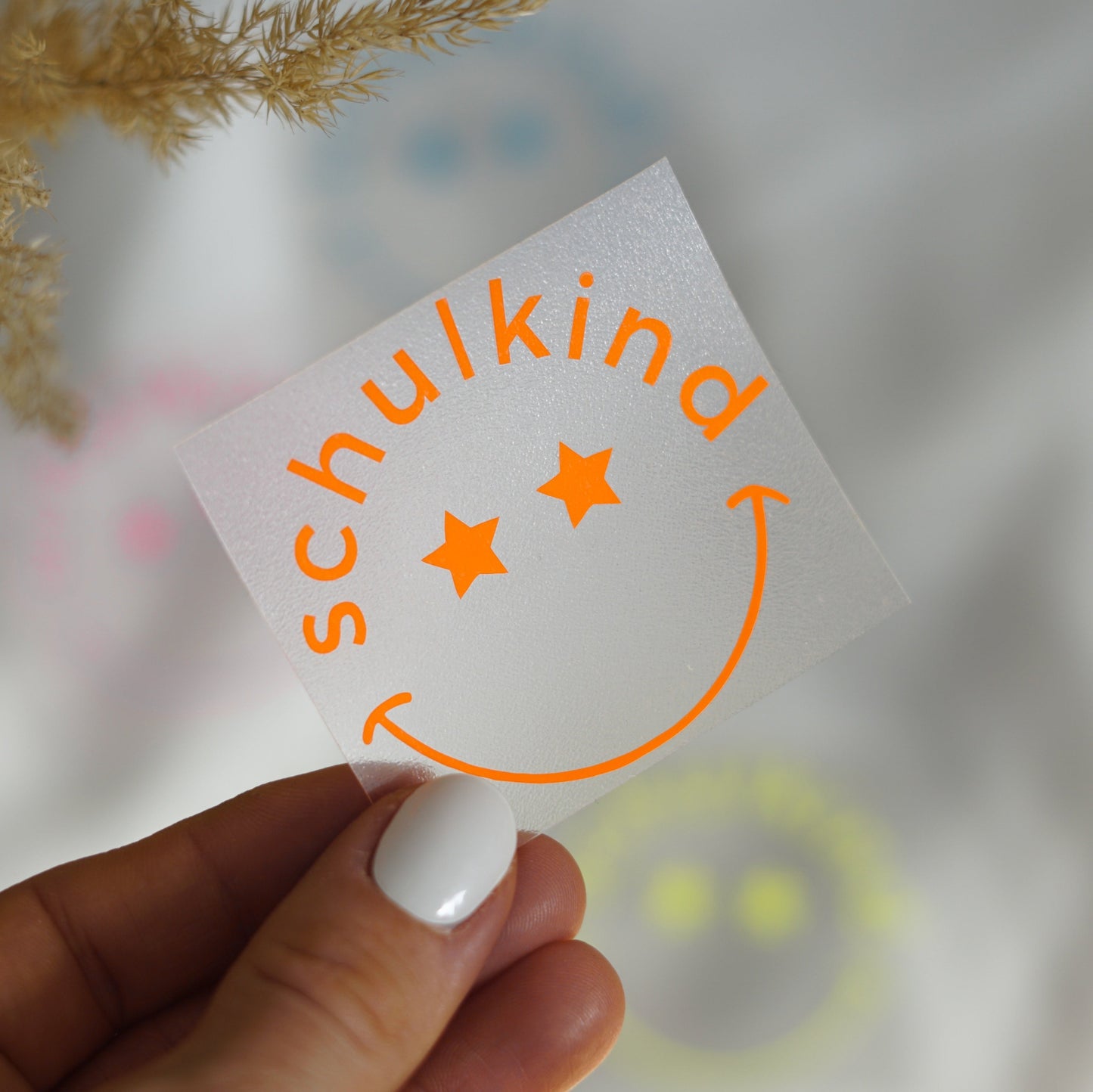 Neon Bügelbild – Schulkind mit lachendem Gesicht und Sternenaugen – leuchtendes Aufbügelmotiv für die Einschulung in Neon Pink, Gelb, Orange, Grün & Blau
