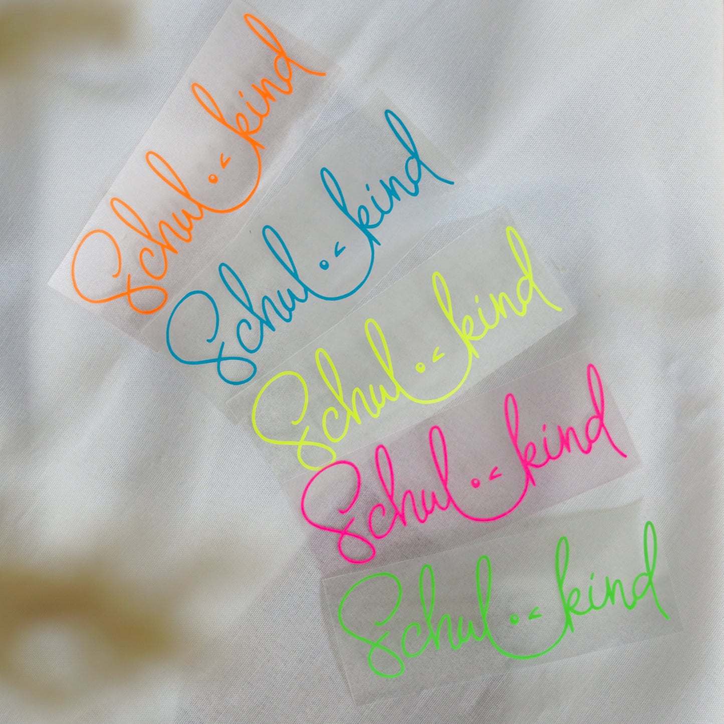 Bügelbild mit „Schulkind“ Schriftzug in Neonfarben für Einschulung und Schule in knalligen Farben: Neon orange, blau, neon gelb, neon pink und neon grün.
