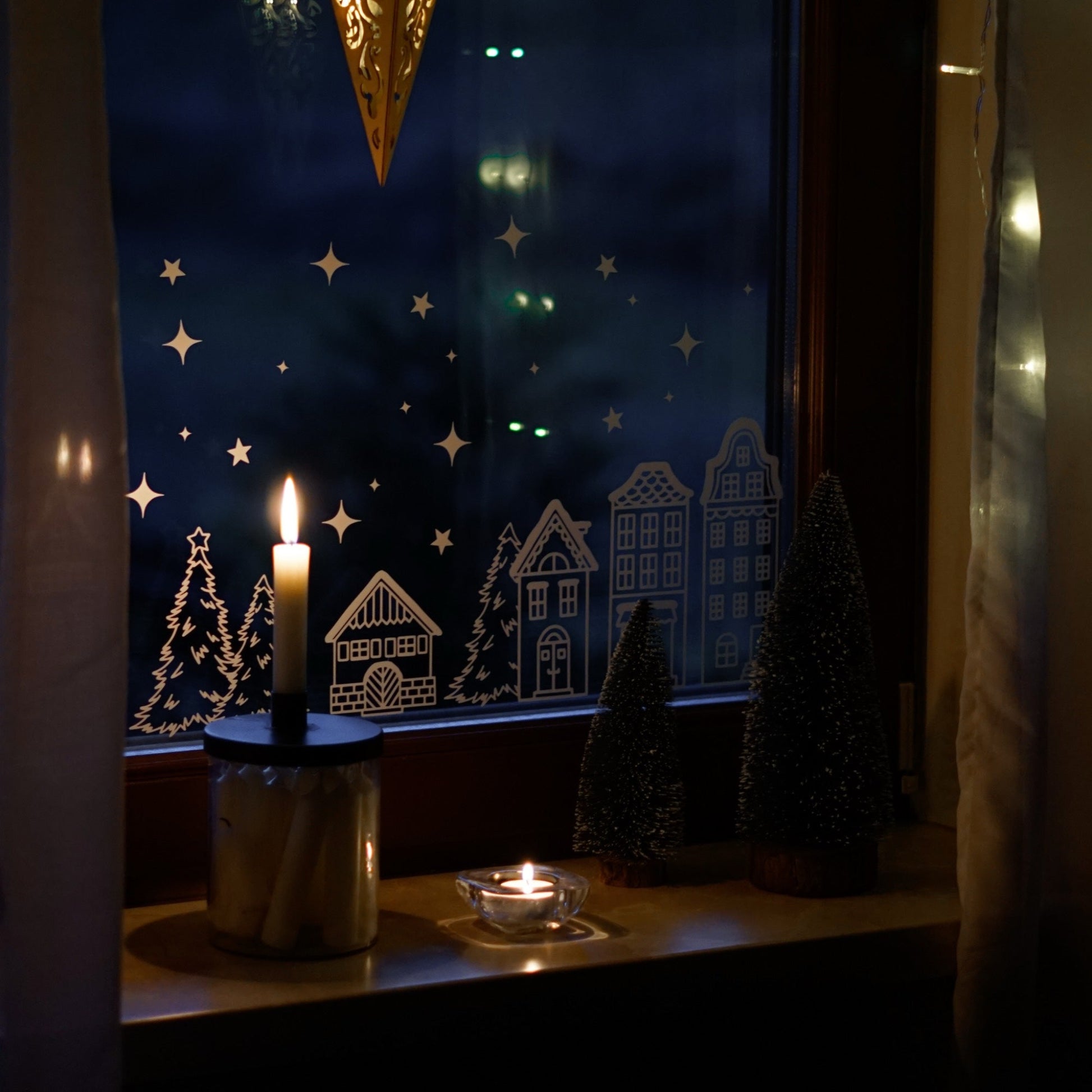 Fenstersticker Winterlandschaft – Weihnachtsdeko Fensterbild mit Häuserreihe, Sternen & Tannen. Skandinavische Winterdeko für dein Zuhause.
