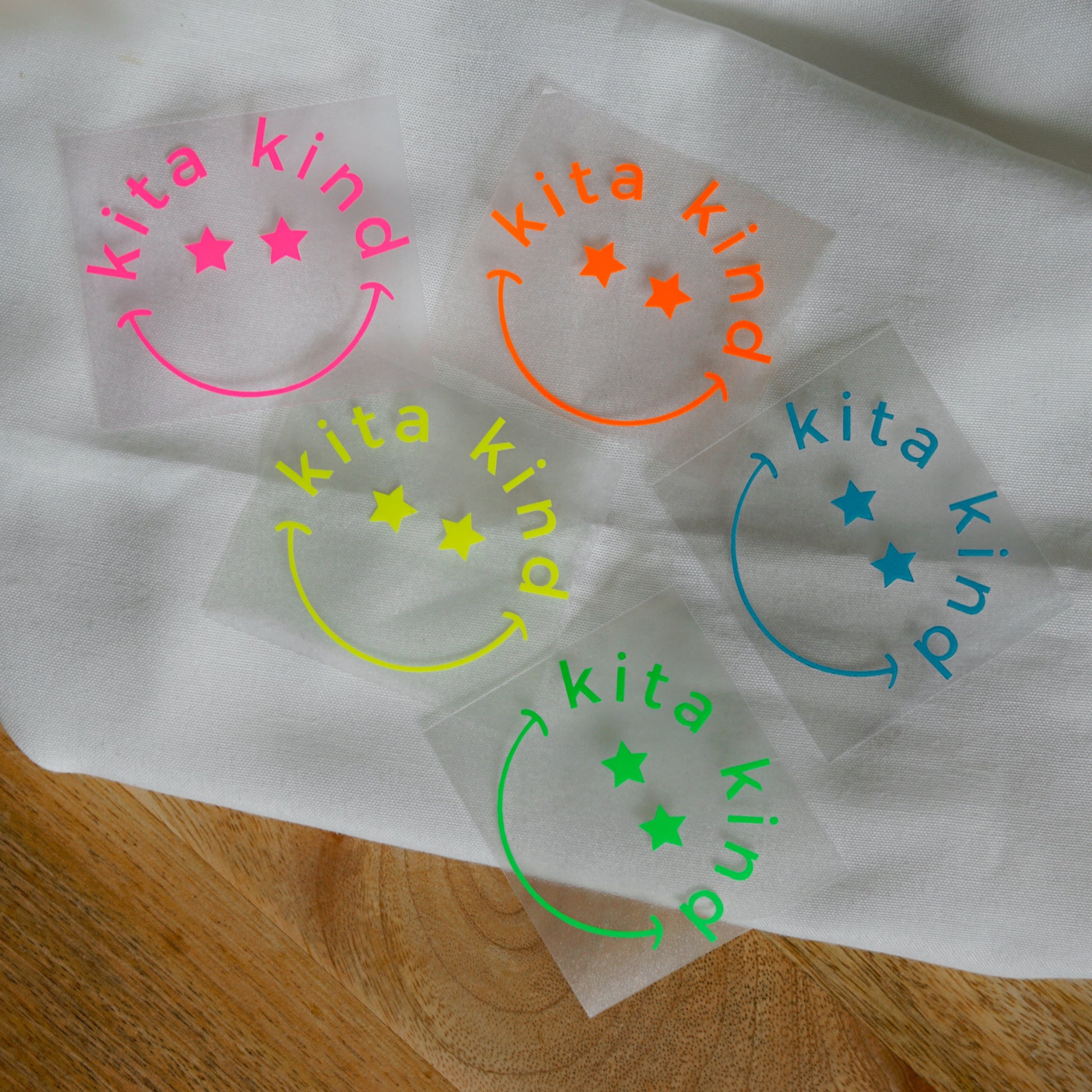 Bügelbild „Kita Kind“ – Smiley mit Sternaugen im Kreis für den ersten Kindergartenstart. Perfekt für T-Shirts, Taschen und Kindergartenartikel.