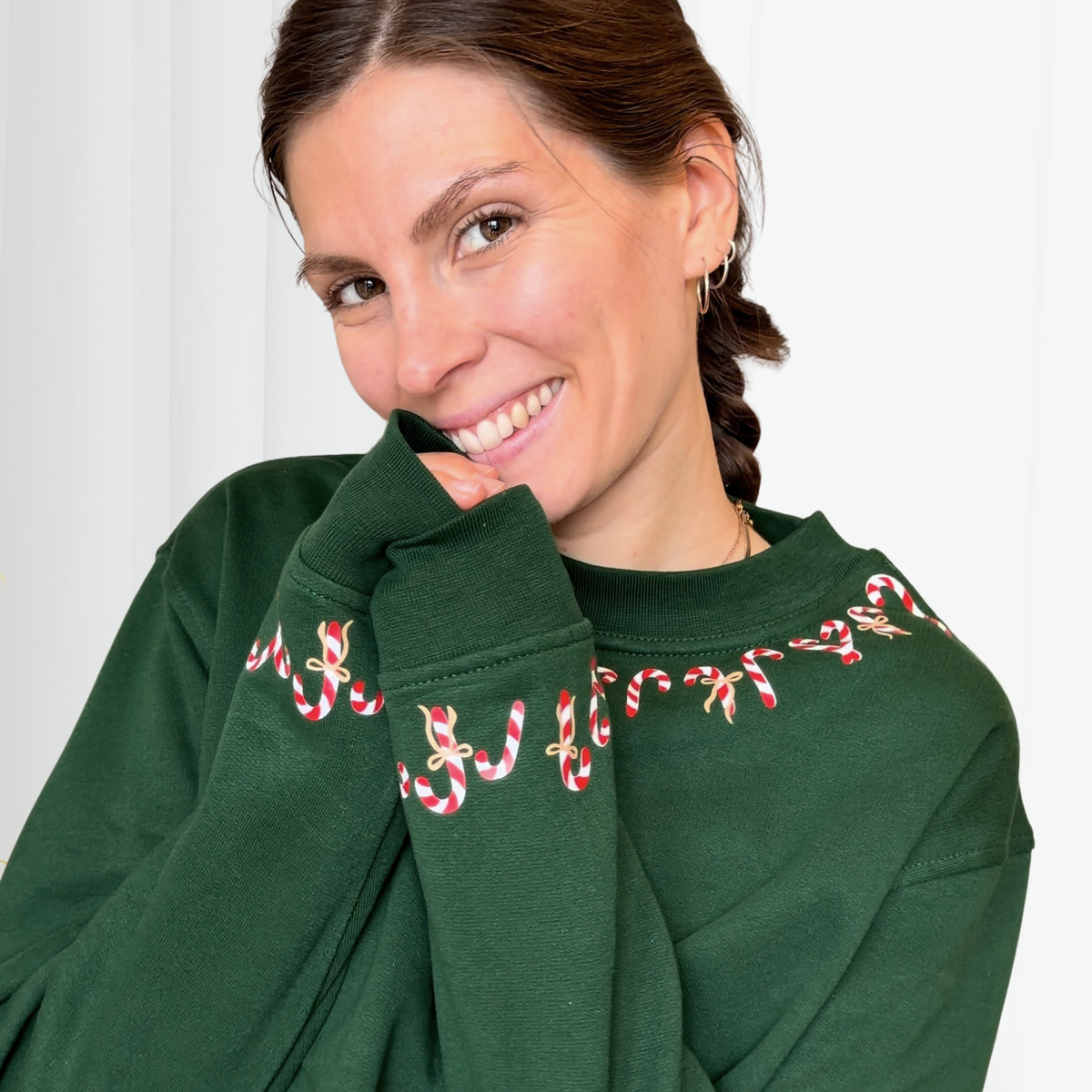 Candy Canes Plotterdatei mit rot-weißen Zuckerstangen und grünen Schleifen, gebogen entlang des Halsbündchens eines Christmas Sweatshirts.