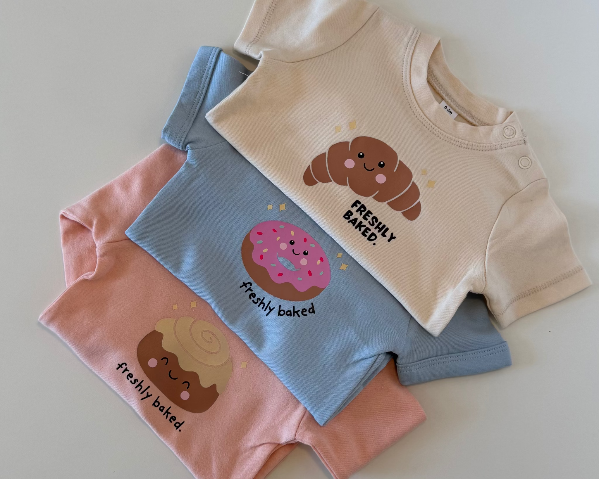 Beispielbild mit drei bedruckten mehrfarbigen Babybodys