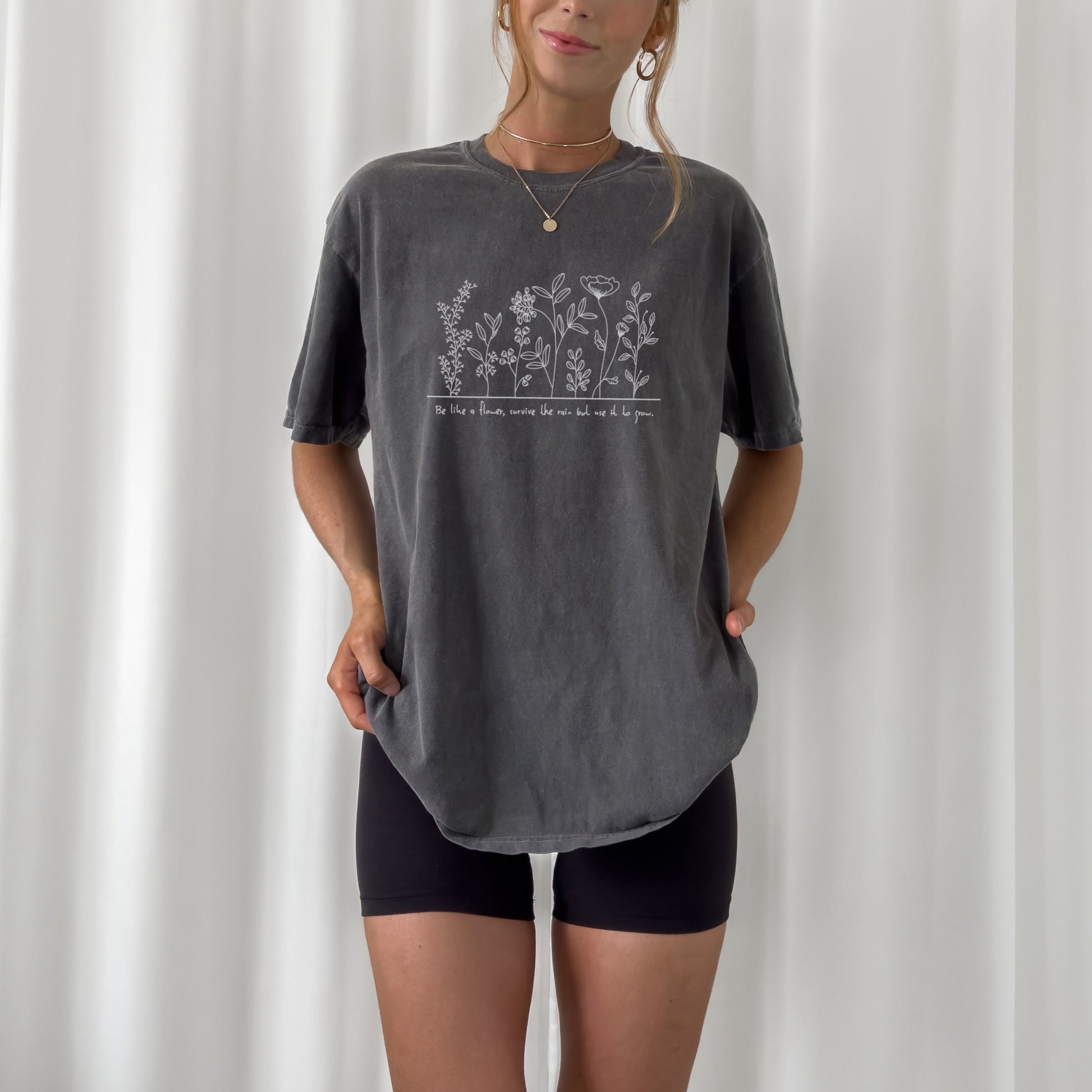 Digitale Plotterdatei mit Blumenwiese und dem Spruch „Be like a flower, survive the rain but use it to grow.“ – filigranes Line Art Design für Shirts, Taschen & Deko.