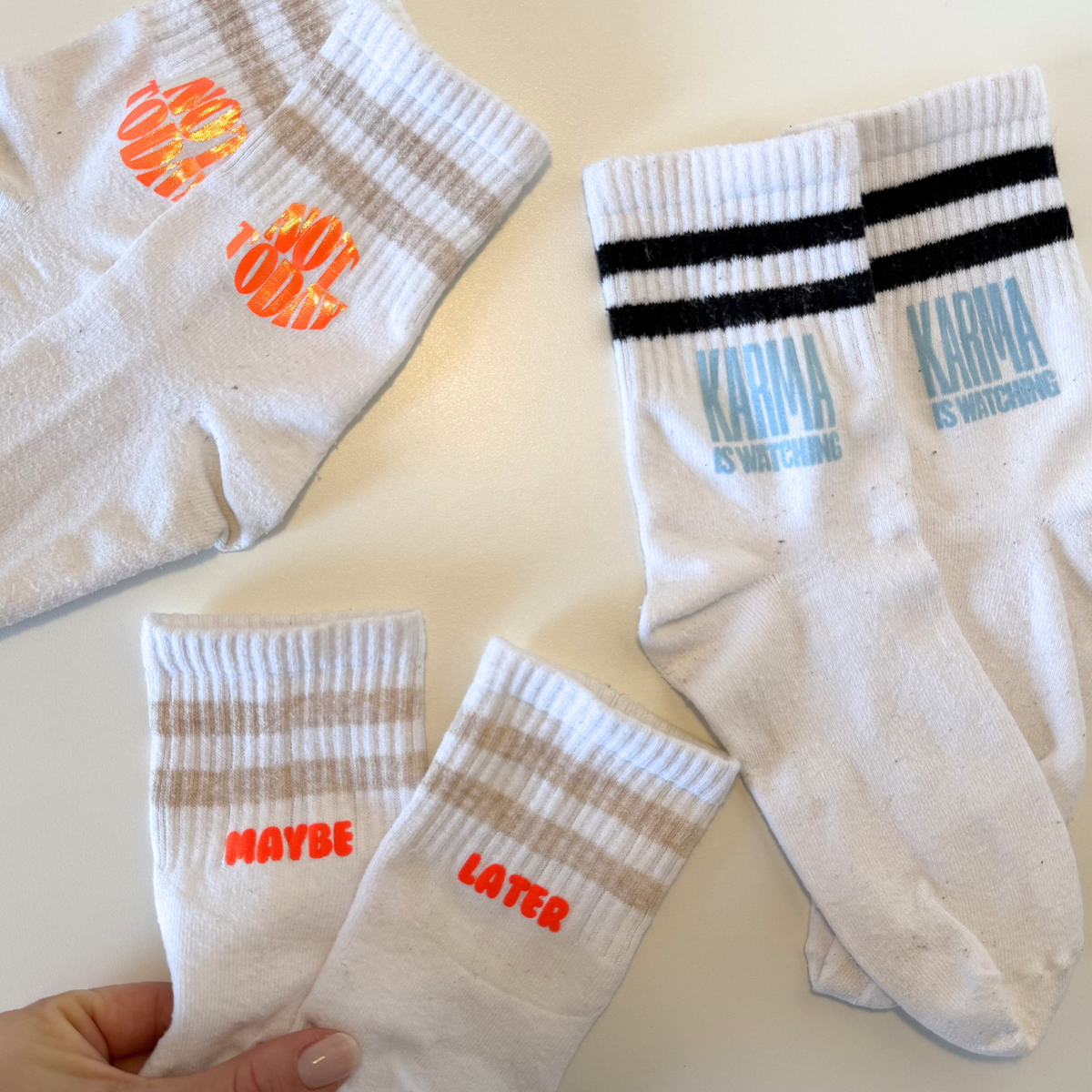 Set aus 23 kleinen Socken Sprüchen als Plotterdatei, minimalistische schwarze Schriftzüge für DIY Statement Socken, geeignet zum klein Plotten (3–4 cm), inkl. SVG DXF PNG Dateien für Cricut und Silhouette, dargestellt auf weißer Socke